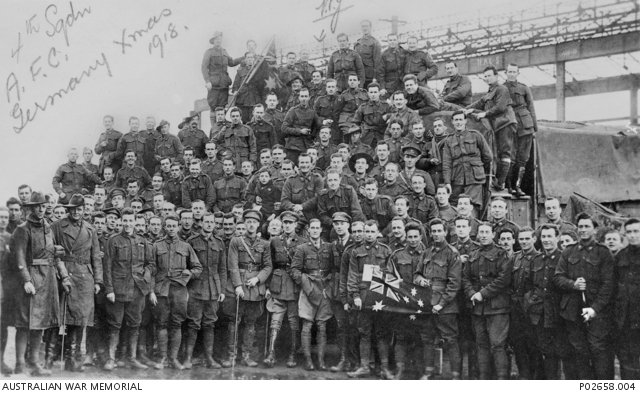 Base aérienne de Bickendorf, Allemagne. Noël 1918. Première apparition de l'orphelin de guerre Henri. Il est au centre de la photo, au milieu des troupes australiennes.